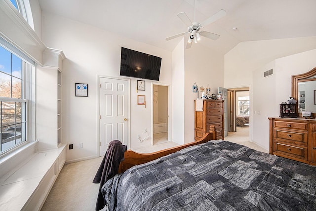 carpeted bedroom with ensuite bathroom, high vaulted ceiling, and ceiling fan