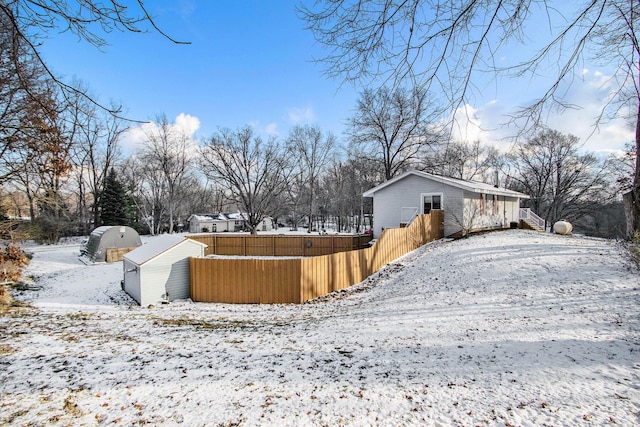 snowy yard with a storage shed