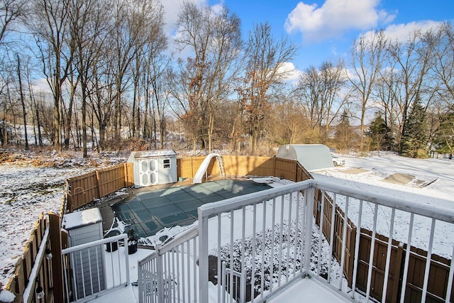 snow covered deck featuring a shed