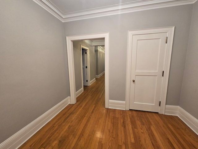 hall with wood-type flooring and ornamental molding