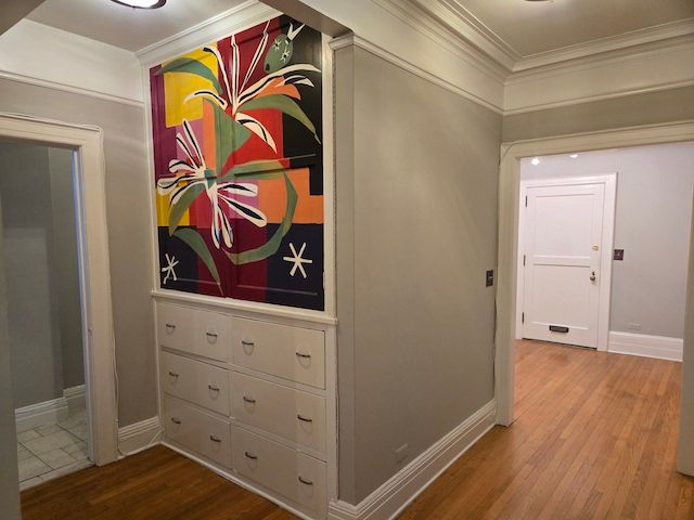 hall with hardwood / wood-style floors and crown molding