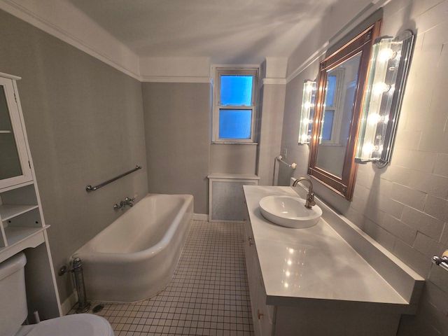 bathroom with a bathing tub, tile patterned flooring, vanity, and toilet