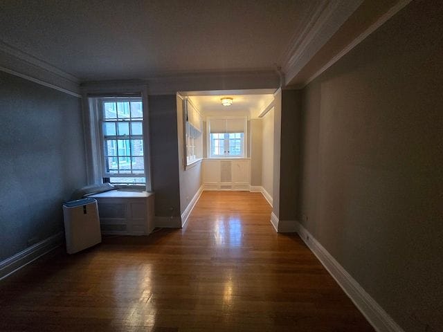 hall featuring crown molding and dark wood-type flooring