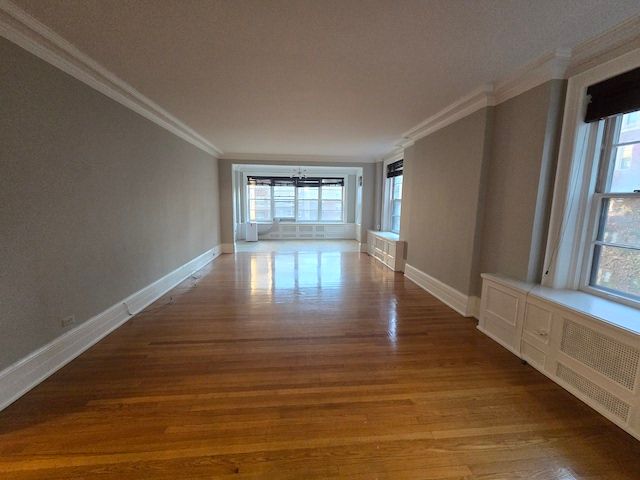 corridor with light hardwood / wood-style floors and ornamental molding