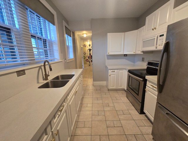 kitchen featuring white cabinets, appliances with stainless steel finishes, and sink