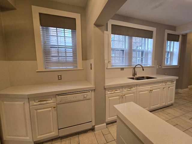 kitchen with white cabinets, dishwasher, light tile patterned flooring, and sink