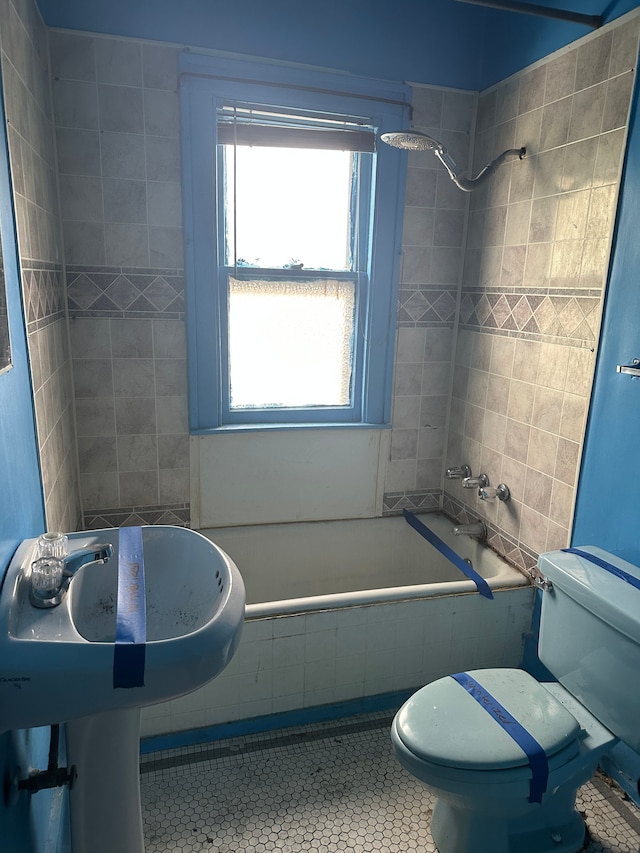 bathroom featuring tile patterned floors, tiled shower / bath combo, and toilet