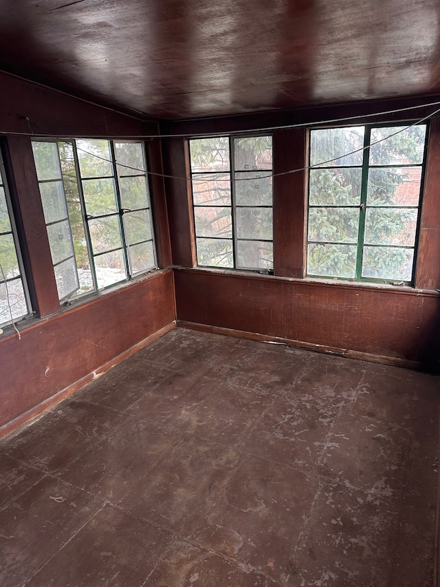 unfurnished sunroom with plenty of natural light and vaulted ceiling