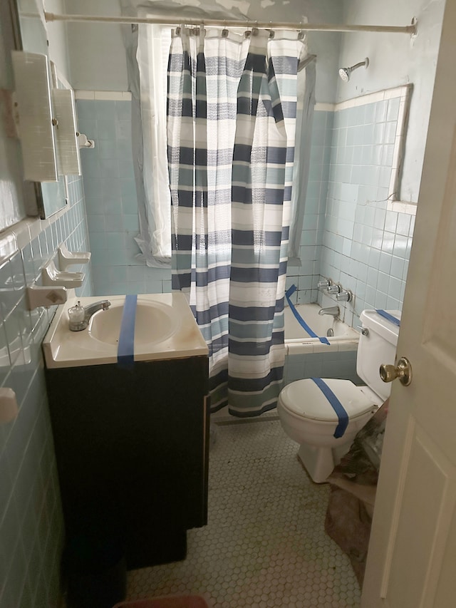 full bathroom featuring vanity, tile patterned floors, toilet, tile walls, and shower / tub combo