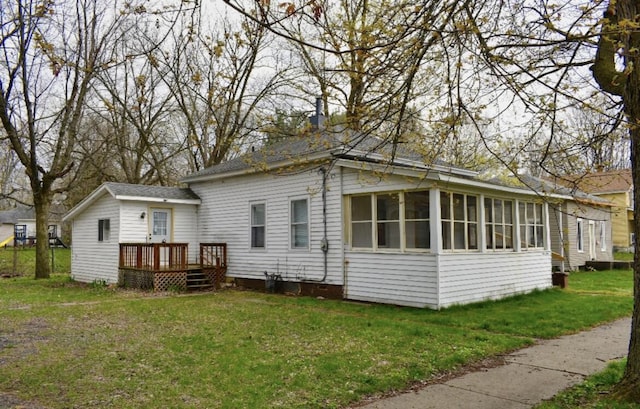 view of side of property featuring a lawn and a sunroom