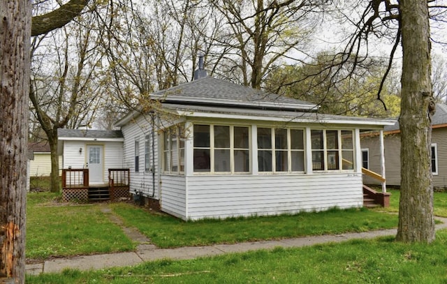 view of property exterior with a sunroom and a yard