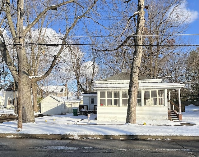 view of front of house featuring a sunroom, an outbuilding, and a garage