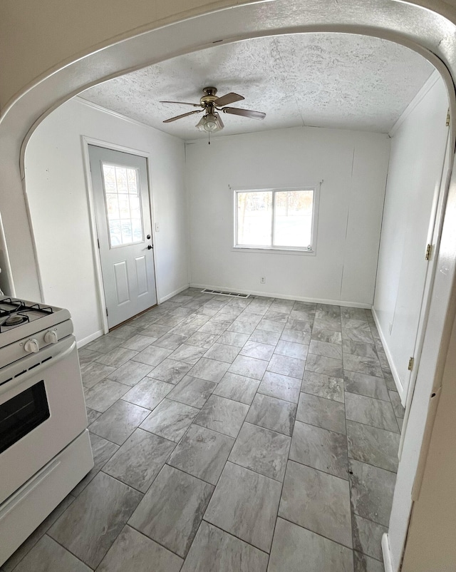 interior space with a wealth of natural light, ceiling fan, and a textured ceiling