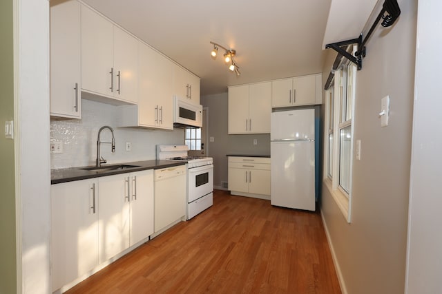 kitchen featuring white cabinetry, tasteful backsplash, white appliances, light hardwood / wood-style flooring, and sink