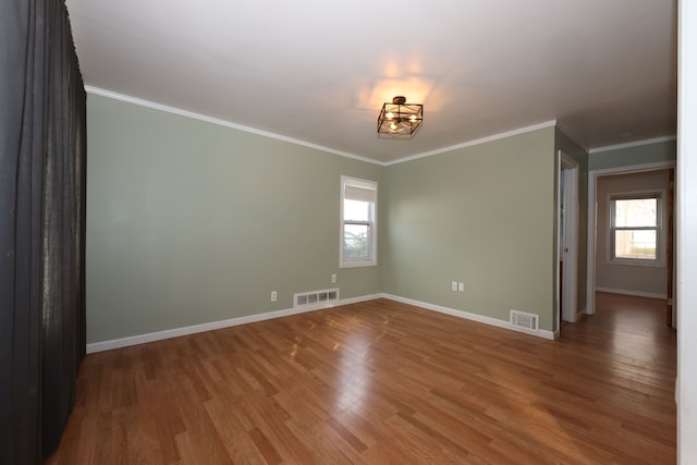 empty room featuring ornamental molding and wood-type flooring