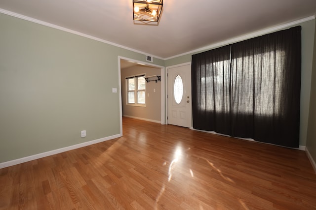 foyer entrance featuring crown molding and hardwood / wood-style floors