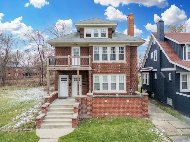 view of front of property featuring a balcony and a front yard