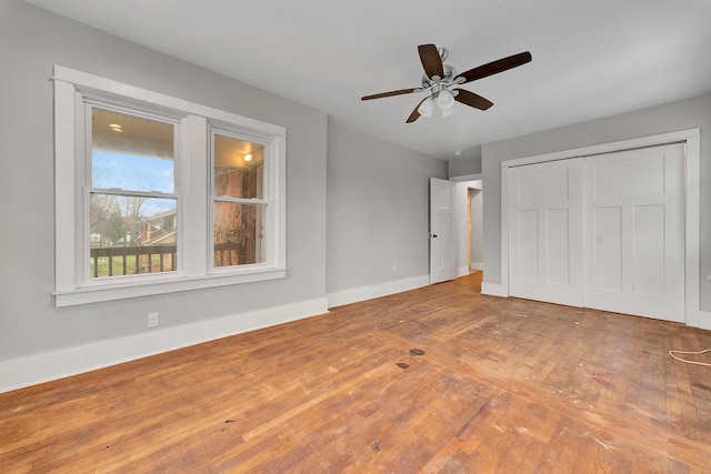 unfurnished bedroom with wood-type flooring, a closet, and ceiling fan