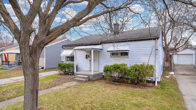 view of front facade featuring a garage, an outdoor structure, and a front lawn