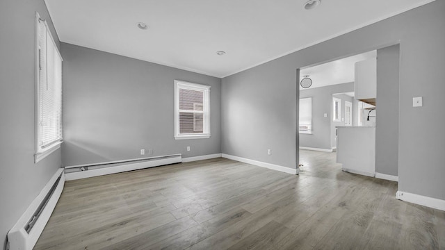 spare room featuring light wood-type flooring and baseboard heating