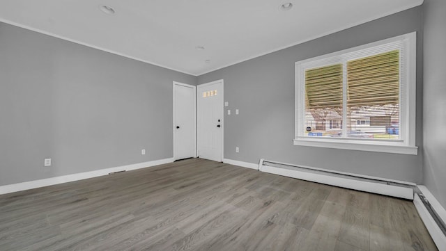 unfurnished room featuring light wood-type flooring, baseboard heating, and ornamental molding