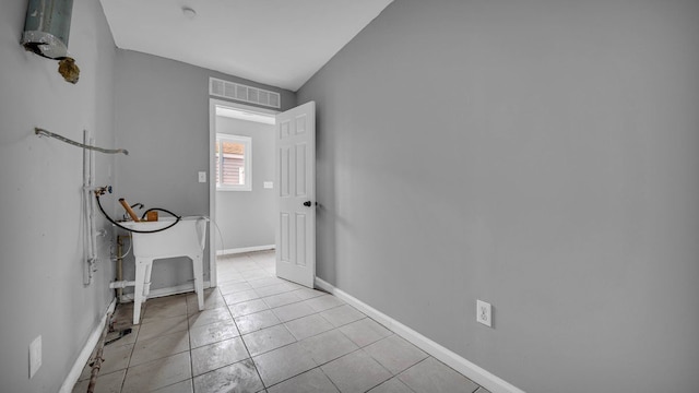 hallway with light tile patterned floors and lofted ceiling