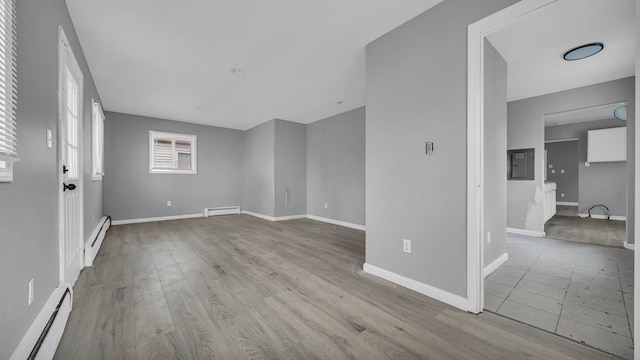 spare room with light wood-type flooring and a baseboard radiator