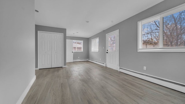 interior space featuring light wood-type flooring and a baseboard heating unit