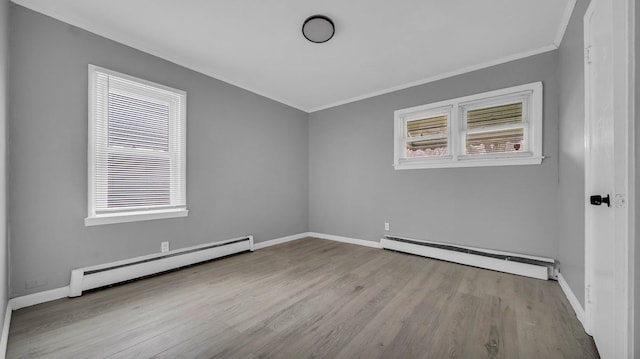 spare room with light wood-type flooring, ornamental molding, and a baseboard radiator