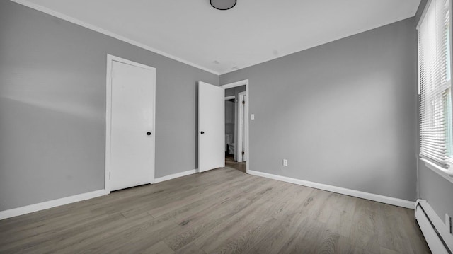 unfurnished bedroom with light hardwood / wood-style floors, baseboard heating, and crown molding