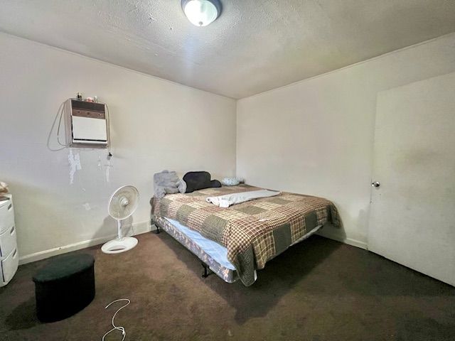 bedroom featuring dark carpet and a wall mounted AC