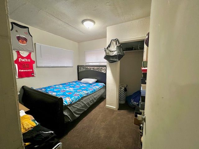 bedroom featuring dark colored carpet