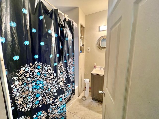 bathroom with vanity and shower / bath combo with shower curtain