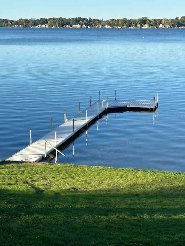 dock area with a water view and a yard