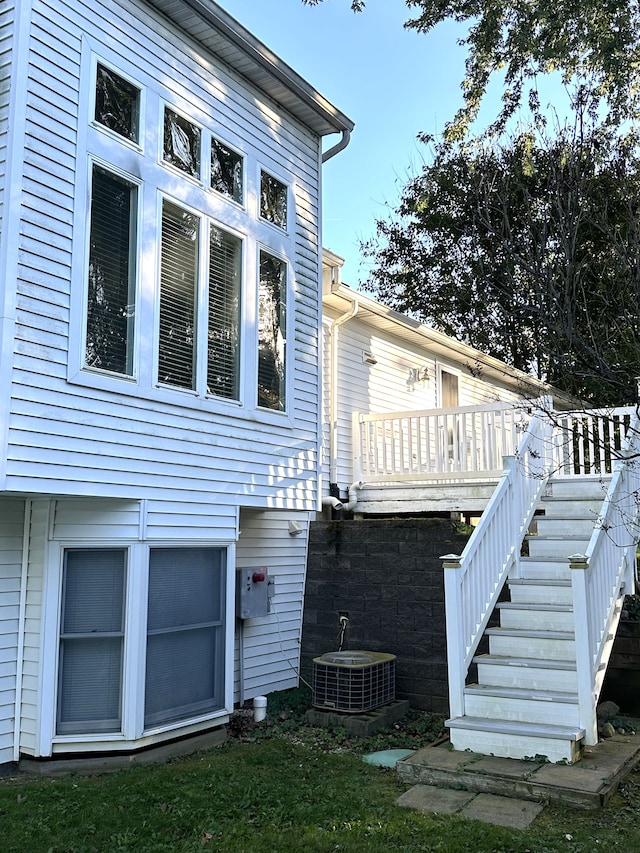 rear view of house featuring a wooden deck and central air condition unit