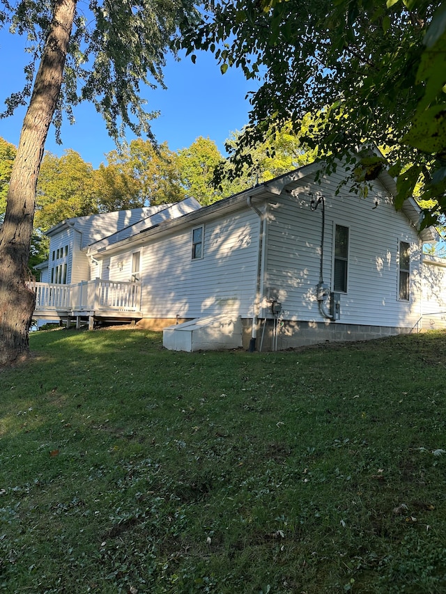 rear view of house with a deck and a yard