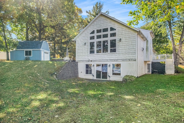 rear view of property featuring a lawn, a garage, and an outdoor structure