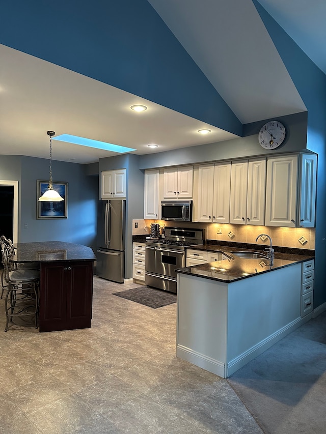 kitchen with backsplash, stainless steel appliances, vaulted ceiling, sink, and pendant lighting