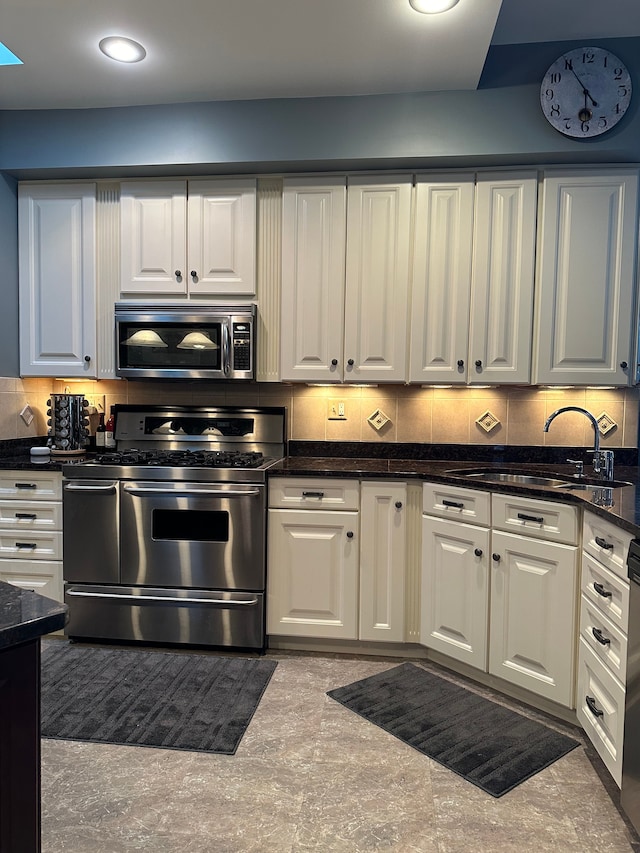 kitchen featuring backsplash, sink, white cabinets, and stainless steel appliances