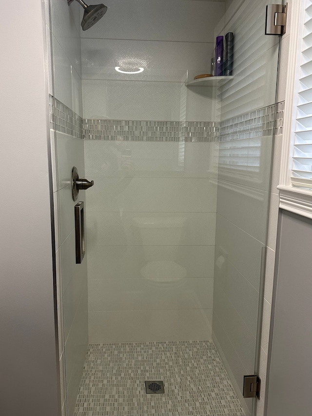 bathroom with a shower with door