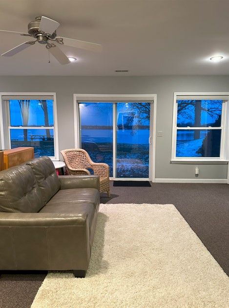 living room featuring ceiling fan and dark colored carpet