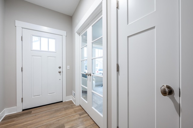 entryway with french doors and light hardwood / wood-style flooring