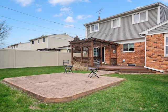 rear view of house with a pergola, a wooden deck, a patio area, and a lawn