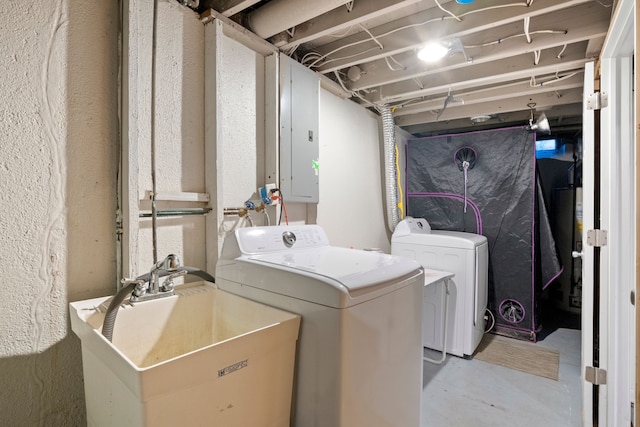 washroom featuring electric panel, washer and clothes dryer, and sink