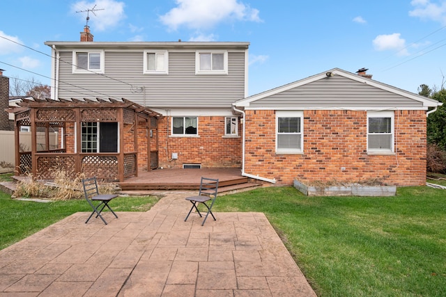 rear view of house featuring a pergola, a wooden deck, a yard, and a patio