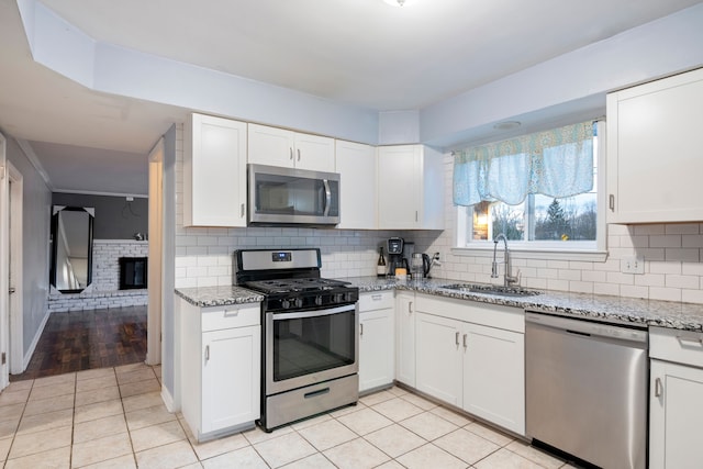 kitchen with stainless steel appliances, white cabinetry, and sink