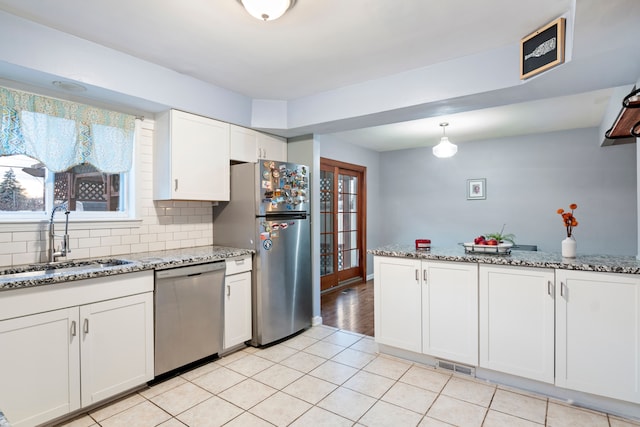 kitchen with white cabinets, a wealth of natural light, sink, and appliances with stainless steel finishes