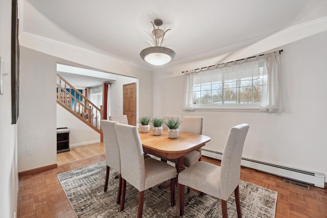 dining space with baseboard heating, parquet floors, and crown molding