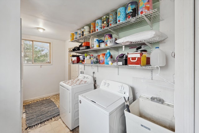 clothes washing area featuring light tile patterned floors, washing machine and dryer, and sink