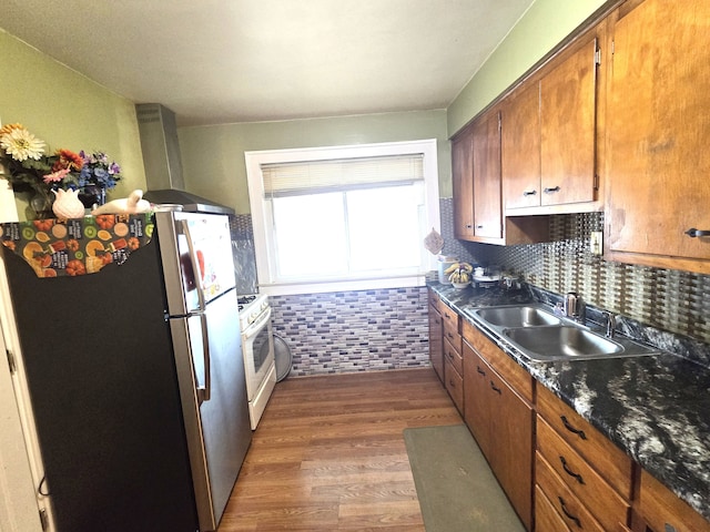 kitchen featuring stainless steel fridge, ventilation hood, dark wood-type flooring, sink, and white range with gas stovetop